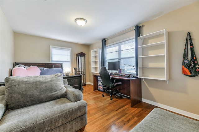 bedroom with multiple windows and wood-type flooring