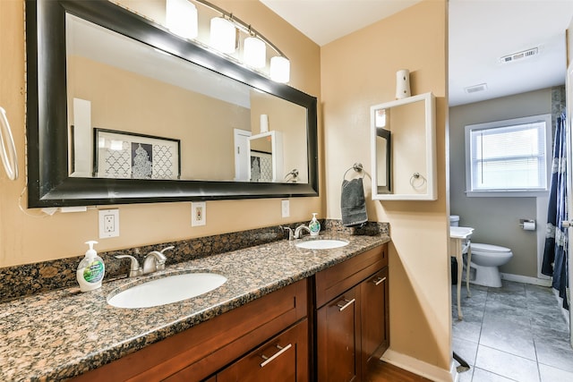 bathroom featuring toilet, vanity, and tile patterned floors