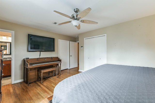 bedroom with light hardwood / wood-style floors, a closet, connected bathroom, and ceiling fan