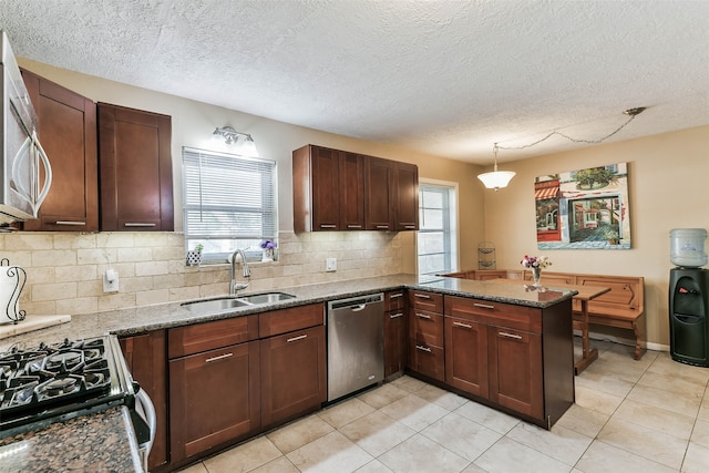 kitchen featuring sink, stainless steel appliances, a wealth of natural light, and kitchen peninsula