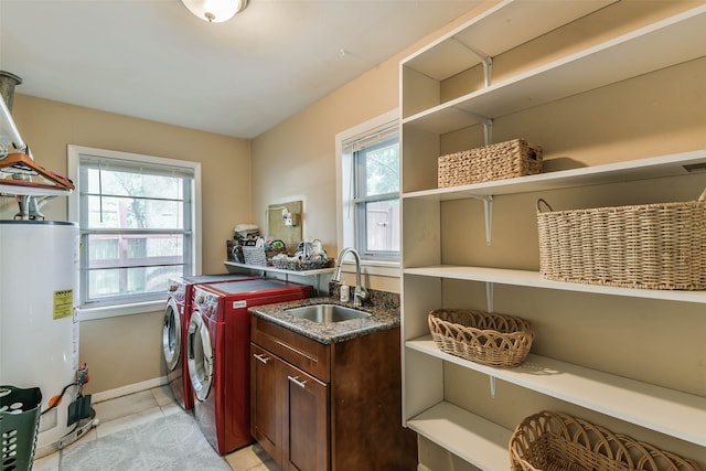 laundry room with sink, water heater, washing machine and dryer, and plenty of natural light