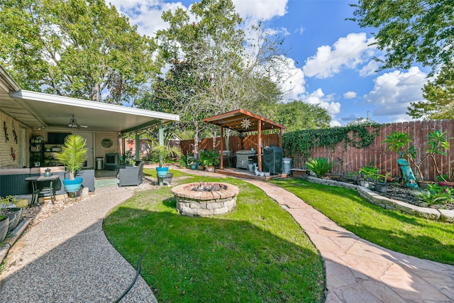 view of yard with an outdoor fire pit, a patio area, and ceiling fan