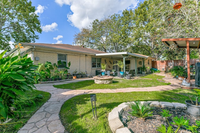 rear view of house with a patio area, an outdoor fire pit, and a lawn