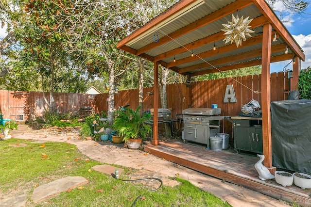 view of patio with area for grilling and a wooden deck