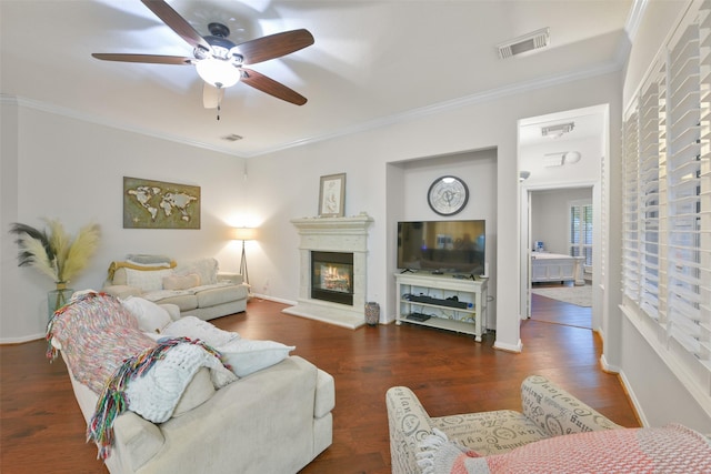 living room with ceiling fan, crown molding, and dark wood-type flooring