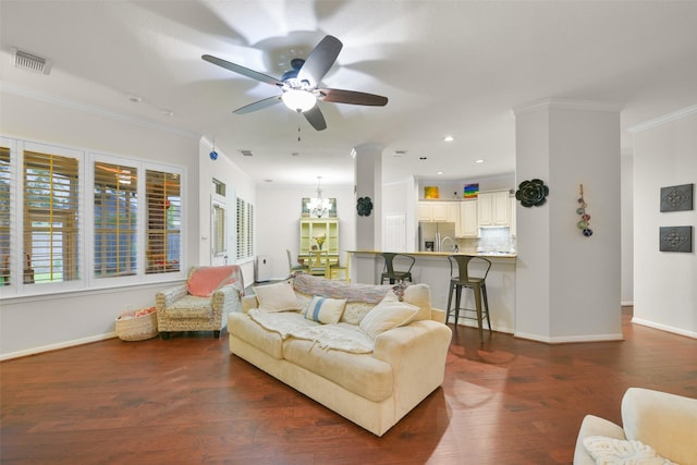 living room featuring ceiling fan with notable chandelier, dark hardwood / wood-style flooring, and ornamental molding