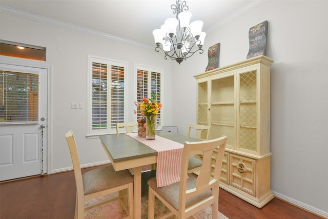 dining room featuring dark hardwood / wood-style flooring, plenty of natural light, ornamental molding, and a notable chandelier