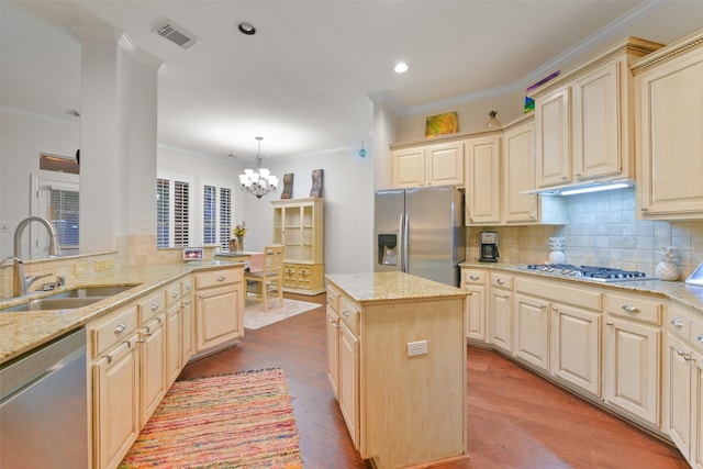 kitchen with a center island, sink, stainless steel appliances, pendant lighting, and light wood-type flooring