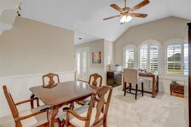 dining area featuring ceiling fan, light carpet, and vaulted ceiling