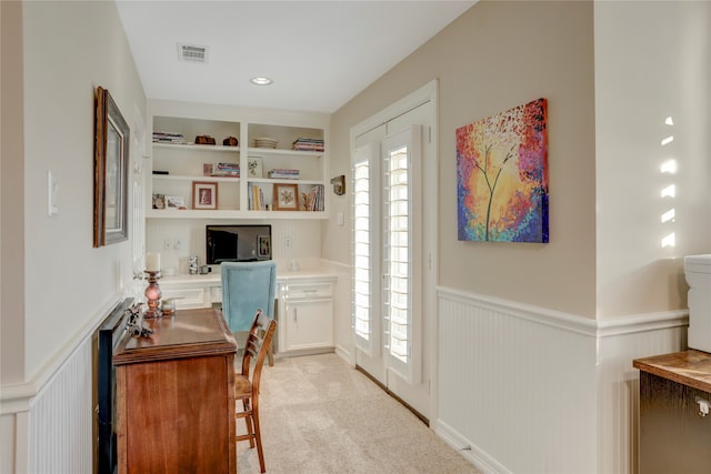 office area featuring built in features, light carpet, and built in desk