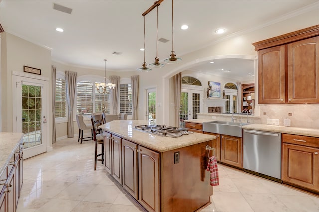 kitchen featuring a kitchen island, appliances with stainless steel finishes, hanging light fixtures, and plenty of natural light