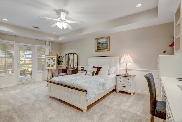 bedroom with ceiling fan, a raised ceiling, access to exterior, and light colored carpet