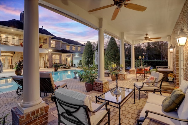 patio terrace at dusk featuring ceiling fan and an outdoor hangout area