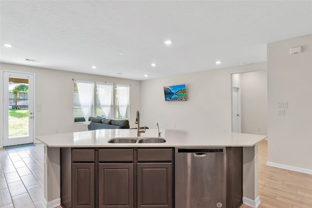 kitchen with stainless steel dishwasher, sink, a center island with sink, and light hardwood / wood-style floors