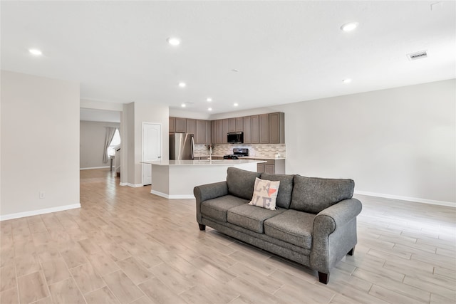 living room with sink and light hardwood / wood-style flooring