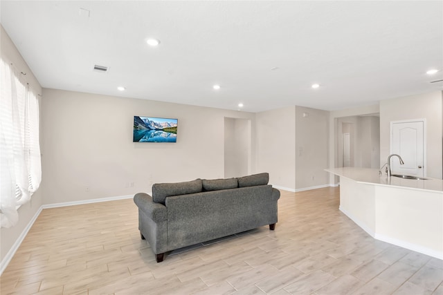 living room featuring sink and light wood-type flooring