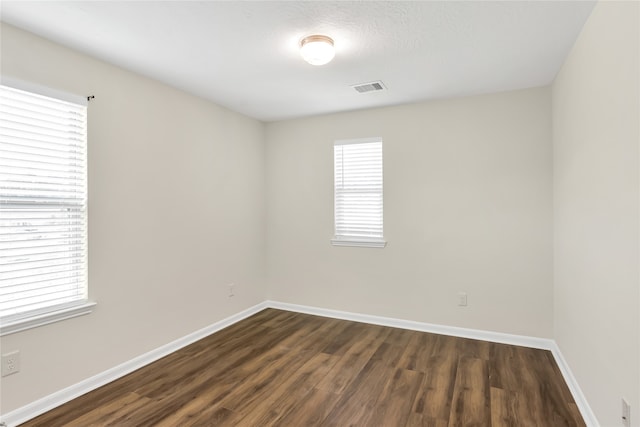 empty room featuring dark wood-type flooring and a textured ceiling