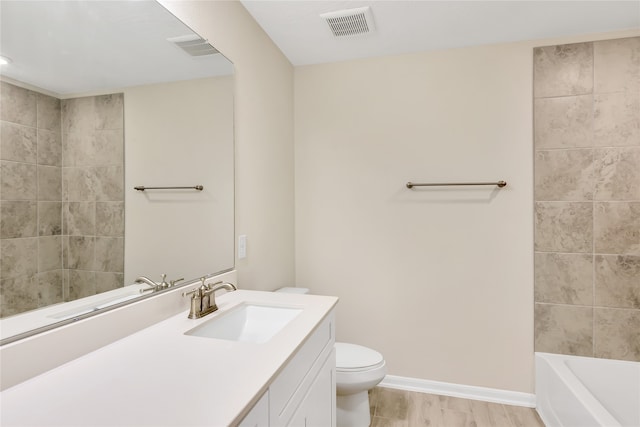 full bathroom featuring toilet, tiled shower / bath, vanity, and wood-type flooring