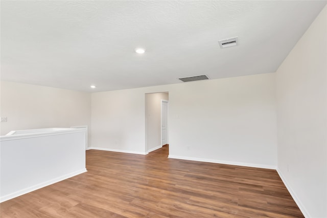 spare room featuring hardwood / wood-style floors and a textured ceiling