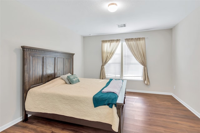 bedroom with dark hardwood / wood-style flooring