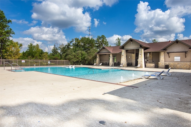 view of swimming pool featuring pool water feature and a patio area