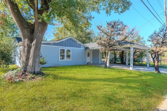 ranch-style home featuring a carport and a front lawn