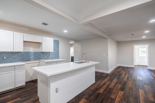 kitchen with a kitchen island with sink, sink, dark hardwood / wood-style floors, decorative backsplash, and white cabinetry