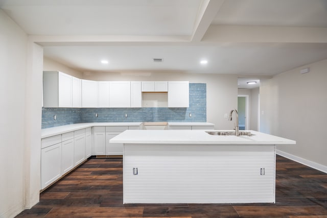 kitchen with backsplash, sink, a center island with sink, white cabinets, and dark hardwood / wood-style floors