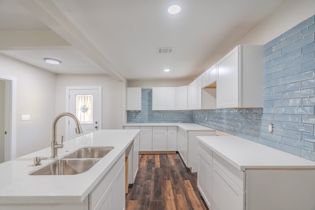 kitchen featuring sink, dark wood-type flooring, tasteful backsplash, a kitchen island with sink, and white cabinets