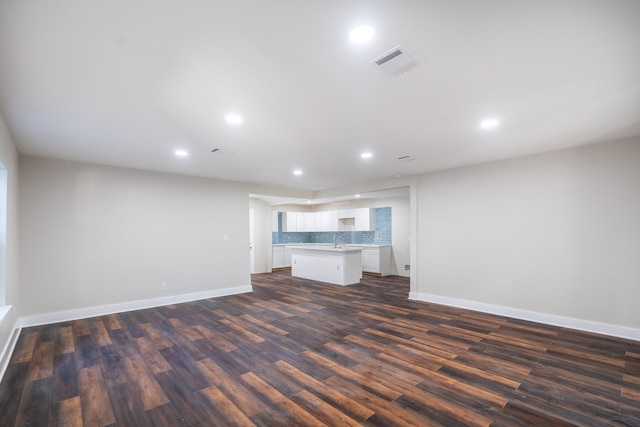 unfurnished living room with dark hardwood / wood-style floors and sink