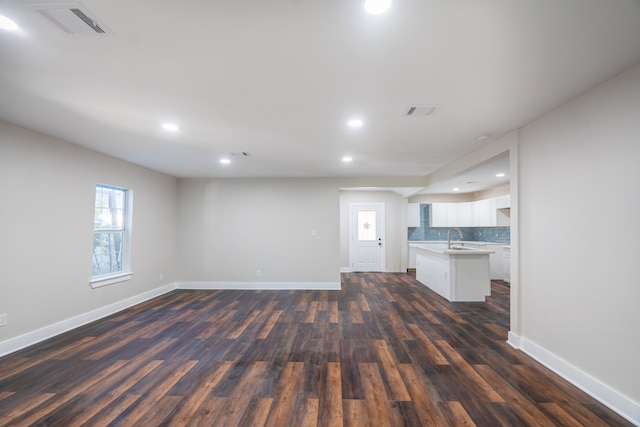 unfurnished living room featuring dark hardwood / wood-style floors and sink