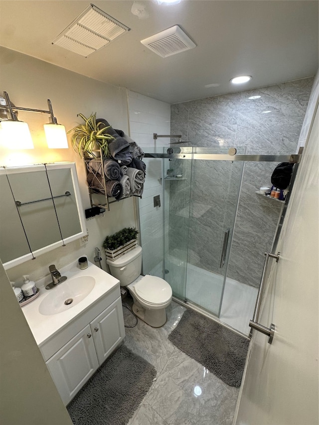 bathroom with a shower with door, vanity, and toilet