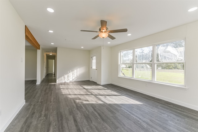 unfurnished living room featuring ceiling fan and dark hardwood / wood-style flooring