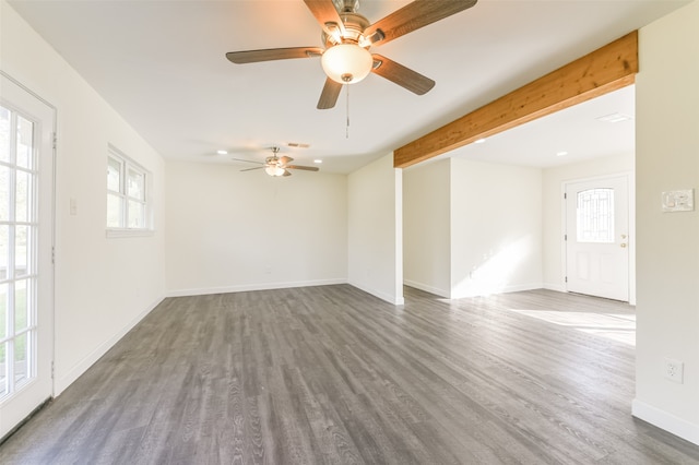 empty room featuring dark hardwood / wood-style floors, beam ceiling, and ceiling fan