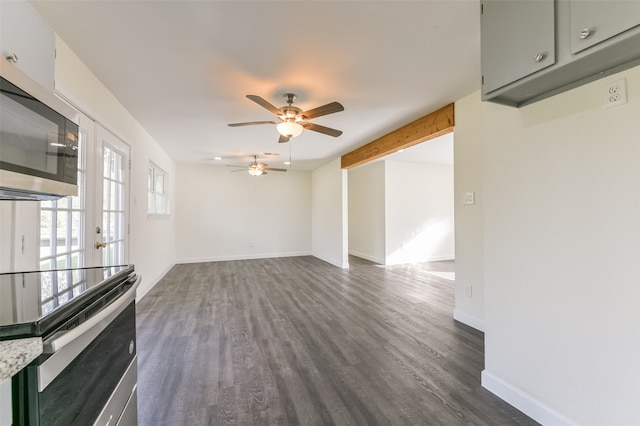 unfurnished living room featuring french doors, beamed ceiling, dark wood-type flooring, and ceiling fan