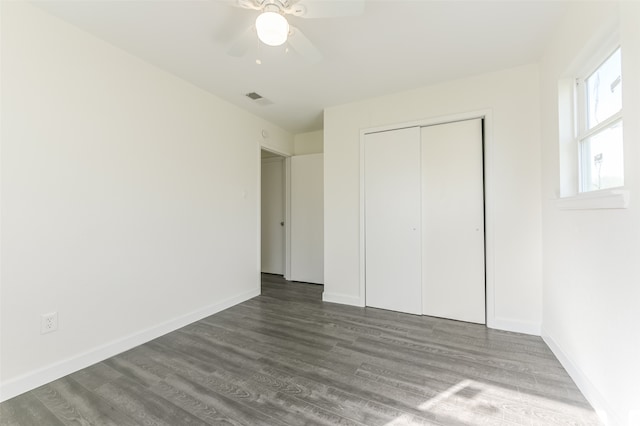 unfurnished bedroom featuring ceiling fan, a closet, and dark hardwood / wood-style flooring