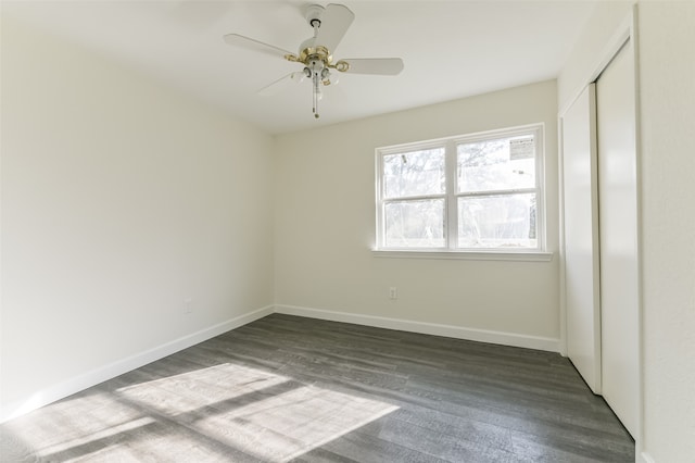 empty room featuring ceiling fan and dark hardwood / wood-style flooring