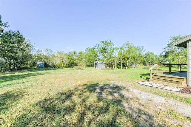 view of yard featuring a deck and a storage unit