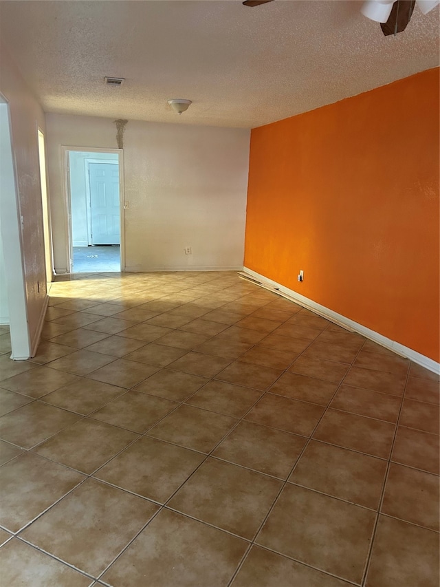 empty room with ceiling fan and a textured ceiling