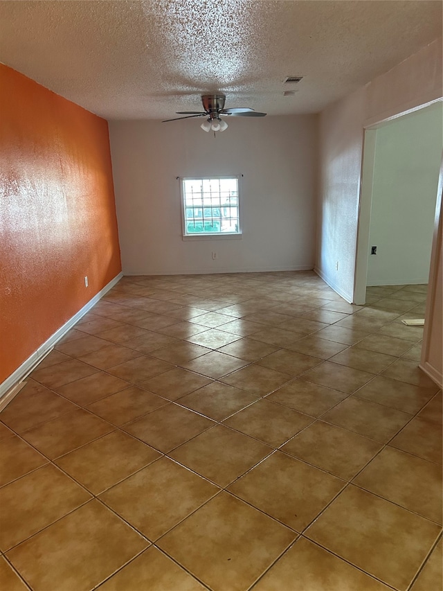 unfurnished room with ceiling fan and a textured ceiling