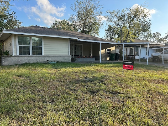 back of property featuring a carport and a lawn