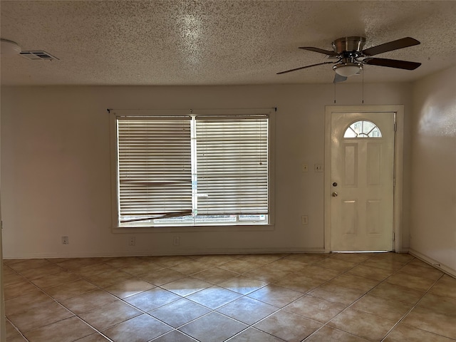 tiled entrance foyer featuring ceiling fan and a textured ceiling