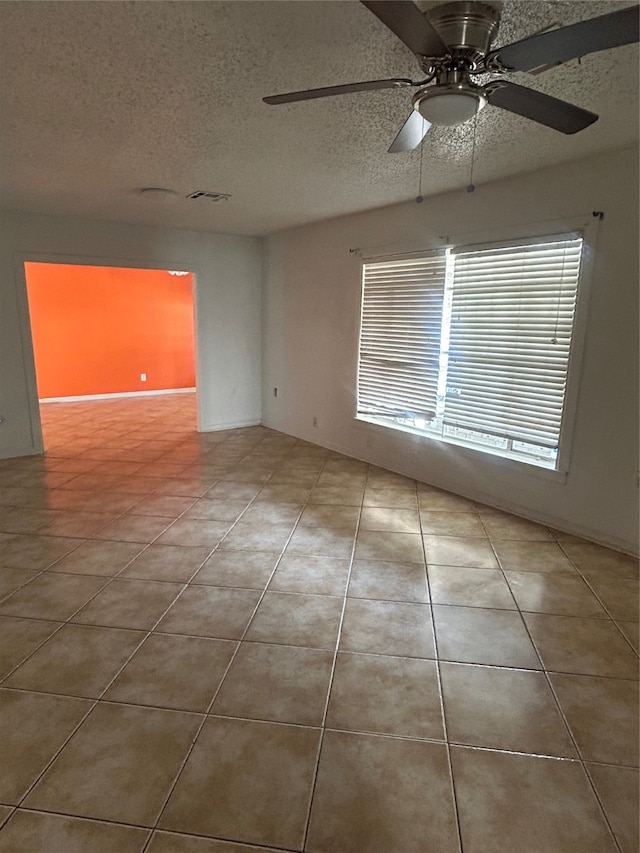 spare room featuring tile patterned floors, a textured ceiling, and ceiling fan