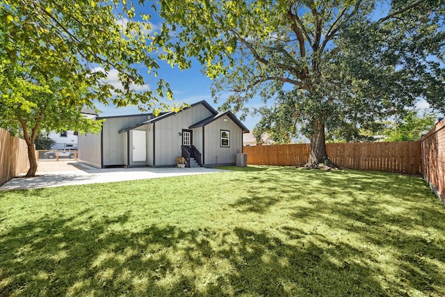 rear view of property featuring central air condition unit, a patio, and a lawn