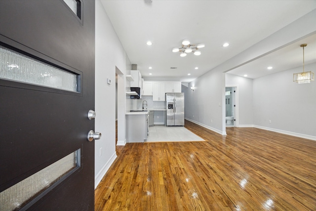 unfurnished living room featuring sink and light wood-type flooring