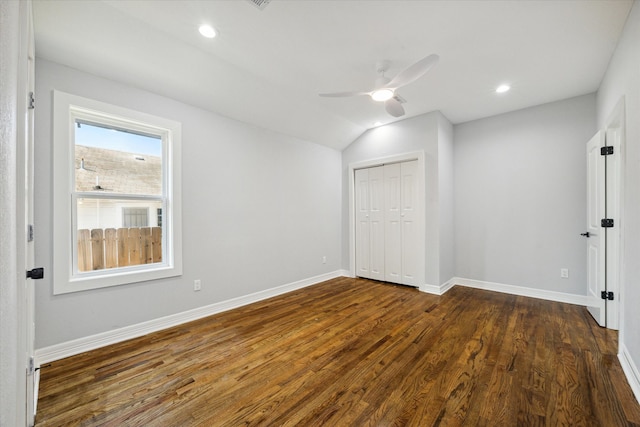 spare room with dark wood-type flooring, vaulted ceiling, and ceiling fan