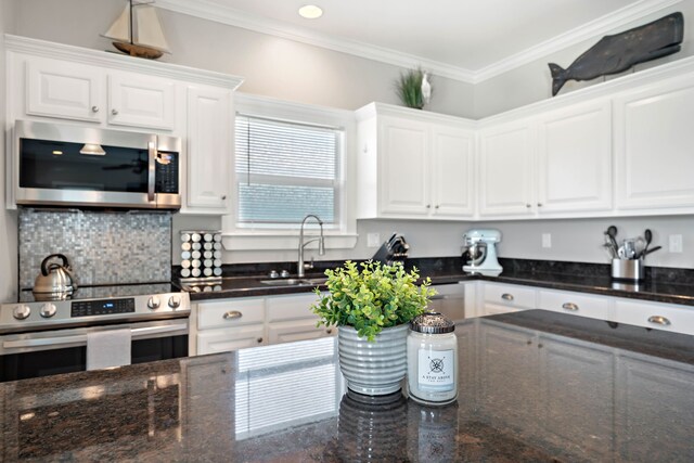 kitchen with ornamental molding, appliances with stainless steel finishes, sink, and white cabinets