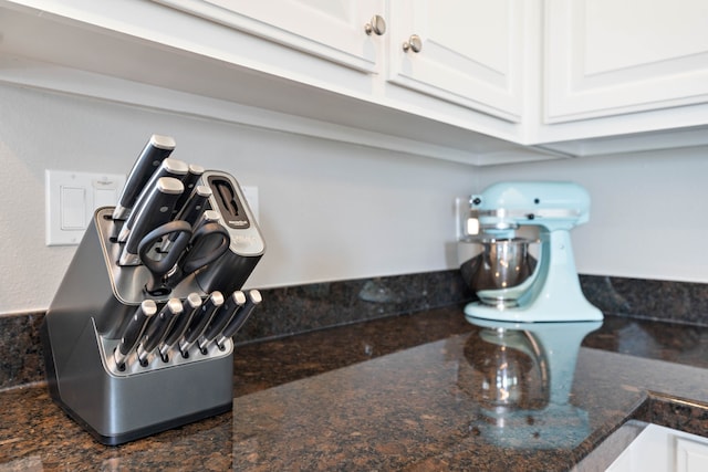 interior details with white cabinets and dark stone countertops