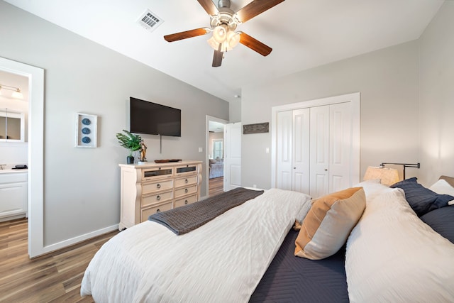 bedroom featuring ensuite bath, hardwood / wood-style flooring, a closet, and ceiling fan