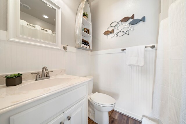 bathroom with vanity, toilet, and wood-type flooring